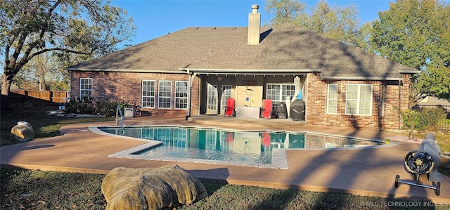 2501 Forest Ridge Parkway, Claremore, OK 74017 - rear view of house featuring brick siding, a patio, a chimney, and roof with shingles