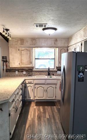 1607 Kay, Durant, OK 74701 - kitchen with freestanding refrigerator, visible vents, a sink, dark wood-type flooring, and light countertops