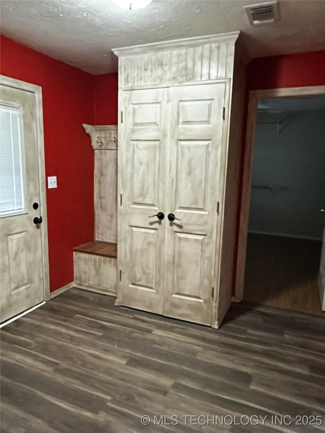 1607 Kay, Durant, OK 74701 - mudroom featuring dark wood finished floors, baseboards, and a textured ceiling