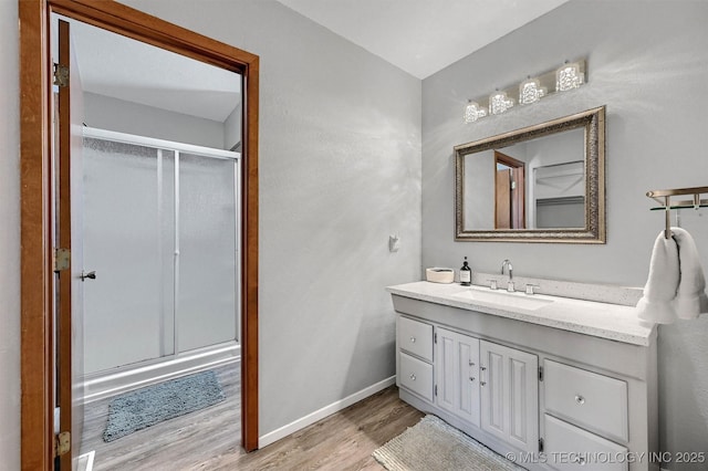 7626 Whispering Way, Kingston, OK 73439 - bathroom with a stall shower, vanity, baseboards, and wood finished floors