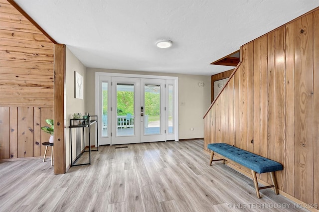 7626 Whispering Way, Kingston, OK 73439 - doorway to outside featuring stairway, wooden walls, baseboards, and light wood-style flooring