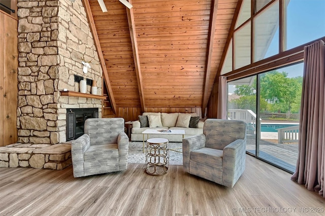 7626 Whispering Way, Kingston, OK 73439 - living room featuring wood ceiling, high vaulted ceiling, wood finished floors, beamed ceiling, and a fireplace