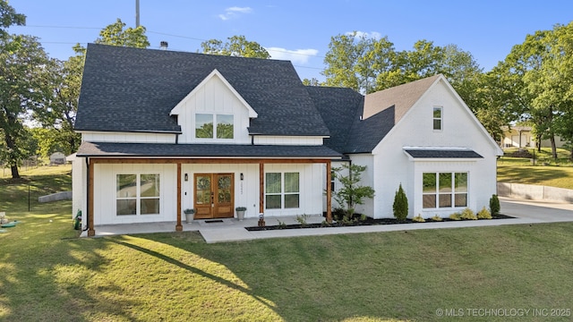 rear view of house featuring a yard, a shingled roof, french doors, and board and batten siding
