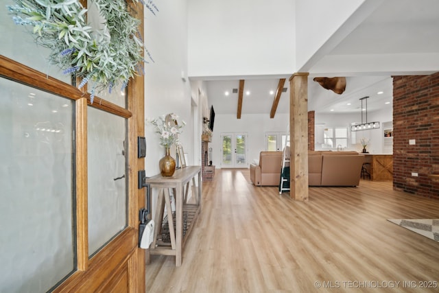 entryway featuring recessed lighting, a high ceiling, beamed ceiling, and light wood-style floors