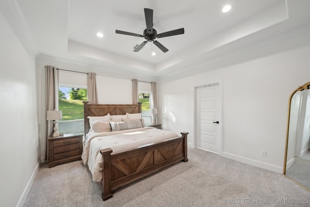 bedroom with a tray ceiling, light carpet, baseboards, and recessed lighting