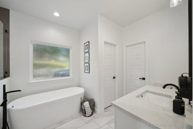 full bath with vanity, marble finish floor, a soaking tub, and recessed lighting