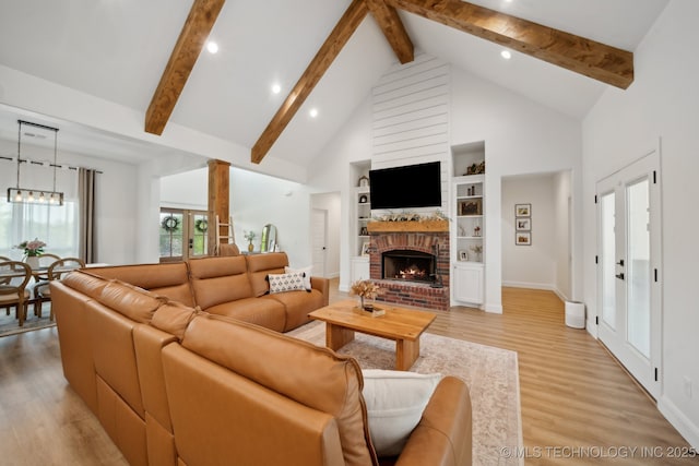 living area featuring high vaulted ceiling, a fireplace, baseboards, beamed ceiling, and light wood-style floors