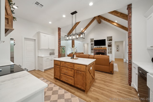 kitchen featuring a warm lit fireplace, beam ceiling, visible vents, white cabinets, and stainless steel dishwasher