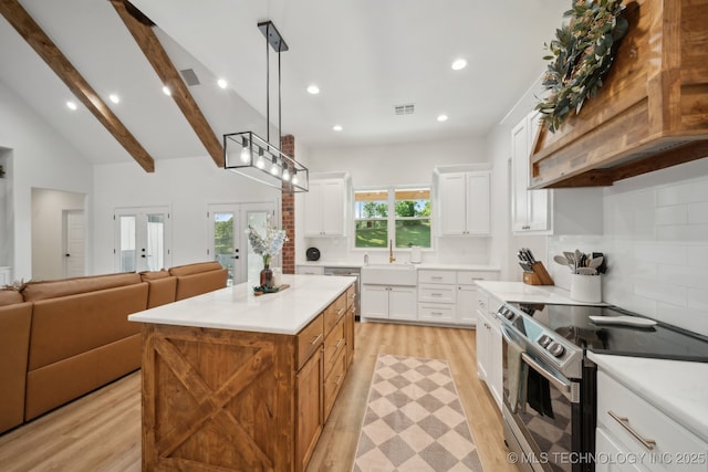 kitchen with open floor plan, light wood-type flooring, visible vents, backsplash, and appliances with stainless steel finishes