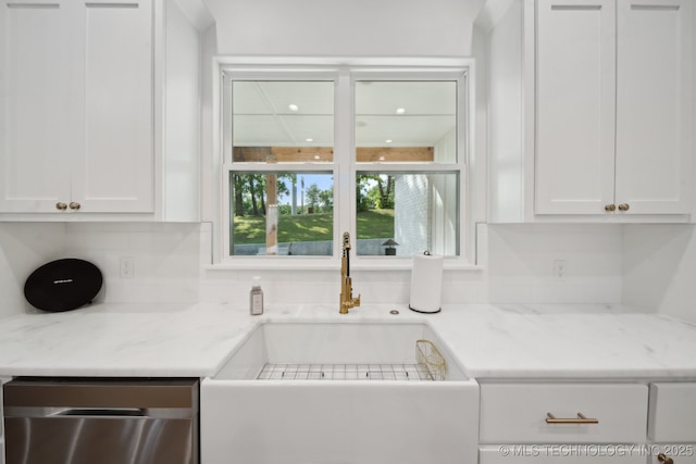 kitchen with a sink, stainless steel dishwasher, decorative backsplash, and white cabinets