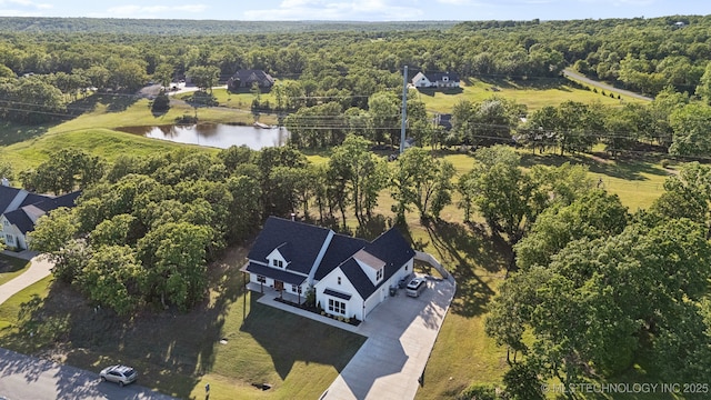 drone / aerial view with a forest view and a water view