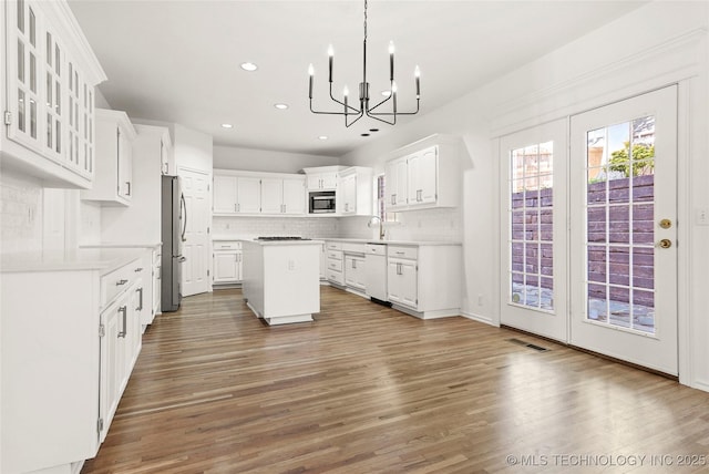 9624 S 68th E Ave, Tulsa, OK 74133 - kitchen with a center island, visible vents, backsplash, appliances with stainless steel finishes, and a chandelier