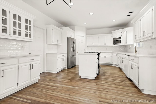 9624 S 68th E Ave, Tulsa, OK 74133 - kitchen with glass insert cabinets, light wood-style floors, white cabinets, appliances with stainless steel finishes, and tasteful backsplash