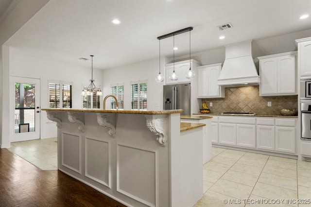 6811 S Sycamore Pl, Broken Arrow, OK 74011 - kitchen with premium range hood, stainless steel appliances, decorative backsplash, light stone counters, and recessed lighting
