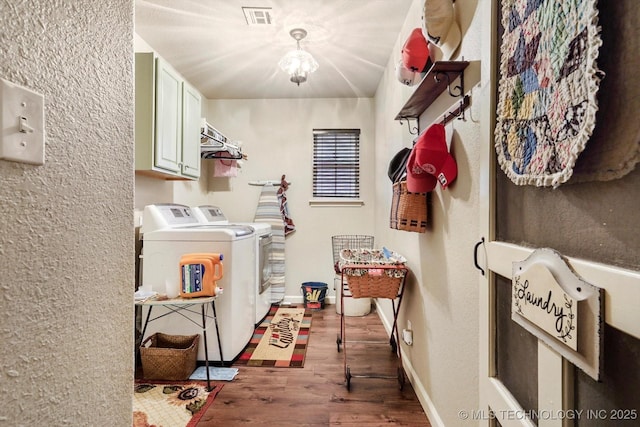 laundry area featuring cabinet space, washer and clothes dryer, wood finished floors, and baseboards