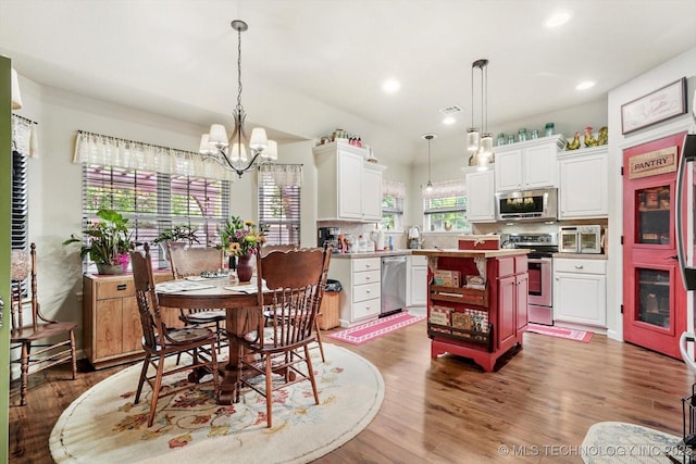 dining area with a chandelier, wood finished floors, and recessed lighting