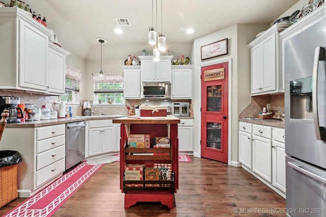 kitchen with appliances with stainless steel finishes, white cabinetry, a sink, backsplash, and recessed lighting