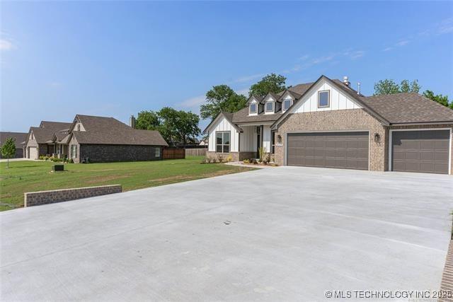 4525 S Holly Ave W, Sand Springs, OK 74063 - view of front of home featuring an attached garage, concrete driveway, a front lawn, and brick siding