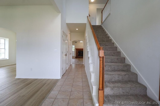 3934 S 199th E Ave, Broken Arrow, OK 74014 - stairway with arched walkways, a fireplace, wood finished floors, and recessed lighting