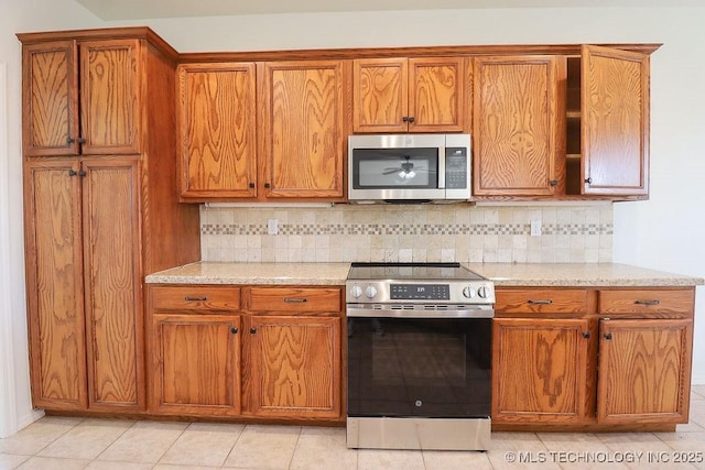 3934 S 199th E Ave, Broken Arrow, OK 74014 - kitchen featuring appliances with stainless steel finishes, brown cabinets, tasteful backsplash, and light stone counters