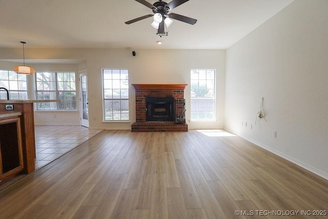 3934 S 199th E Ave, Broken Arrow, OK 74014 - unfurnished living room featuring light wood-style floors, a brick fireplace, and a ceiling fan