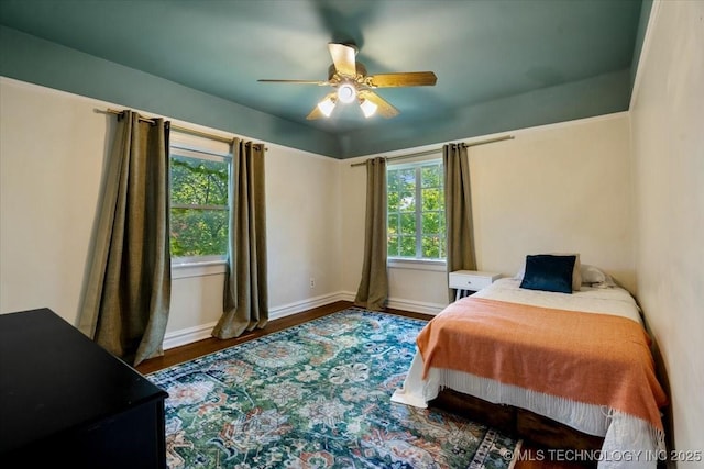 bedroom with baseboards, a ceiling fan, and wood finished floors
