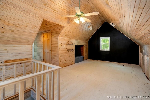 bonus room with lofted ceiling, wooden walls, ceiling fan, and wooden ceiling