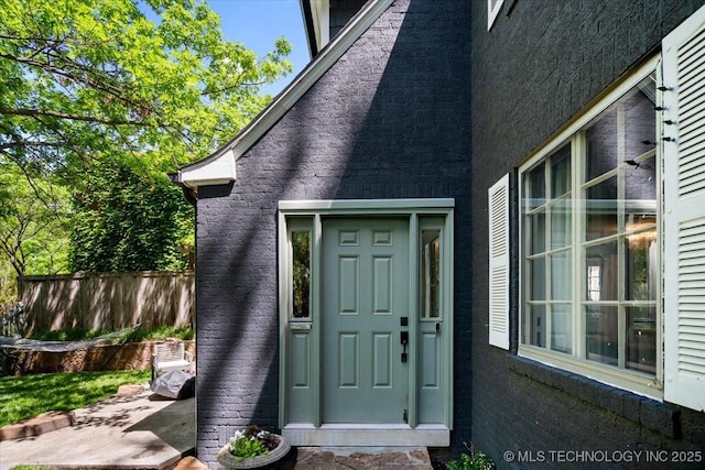 entrance to property featuring fence