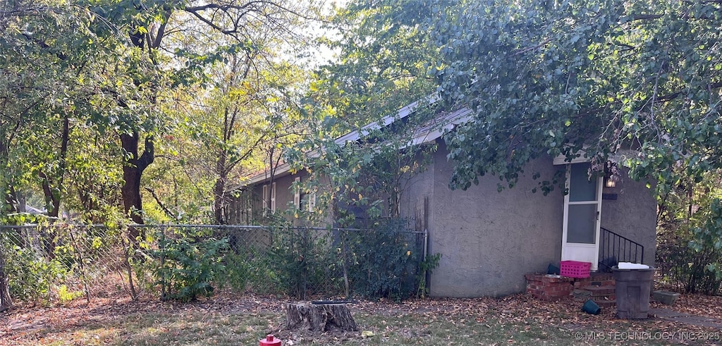 view of home's exterior featuring fence and stucco siding