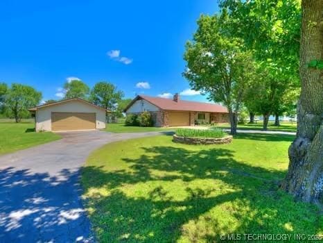 view of front of house featuring a front lawn and a detached garage