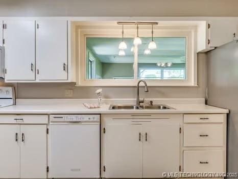 kitchen featuring white cabinets, dishwasher, light countertops, and a sink