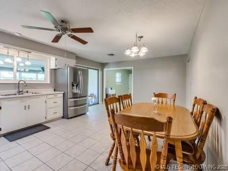 dining room featuring light tile patterned floors and ceiling fan with notable chandelier