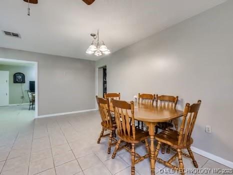 dining space with light tile patterned flooring, a notable chandelier, baseboards, and visible vents