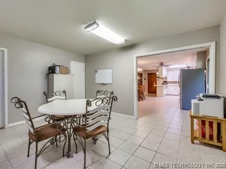 dining space with light tile patterned floors, baseboards, and ceiling fan
