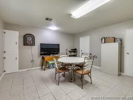 dining space with light tile patterned floors, visible vents, and baseboards