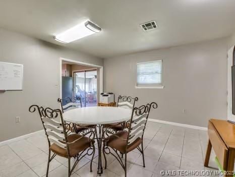 dining area with light tile patterned floors, baseboards, and visible vents