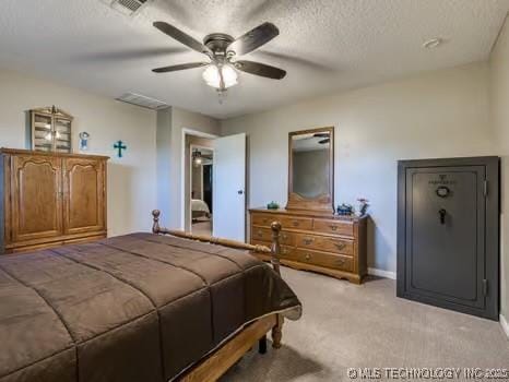 bedroom featuring a textured ceiling, visible vents, baseboards, ceiling fan, and light carpet