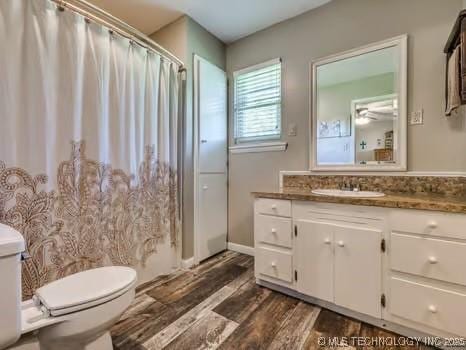 full bathroom with toilet, wood finished floors, vanity, and a shower with curtain