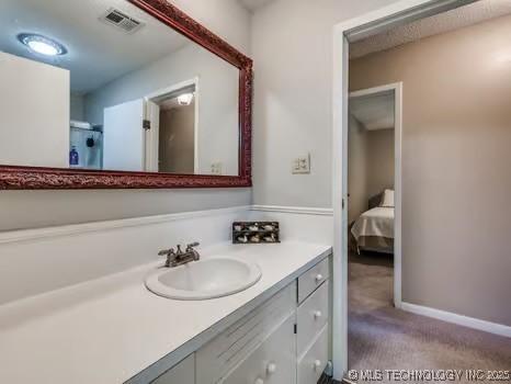 bathroom featuring vanity, baseboards, and visible vents