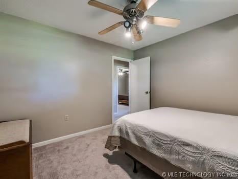 carpeted bedroom featuring baseboards and a ceiling fan