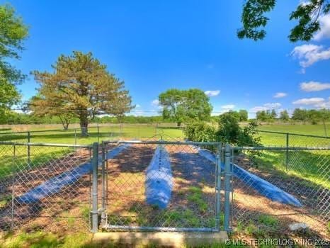 exterior space featuring a rural view, a gate, and fence