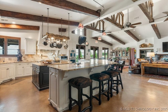 9639 Horizon Cir, Sperry, OK 74073 - kitchen featuring tasteful backsplash, concrete flooring, beam ceiling, a spacious island, and a ceiling fan