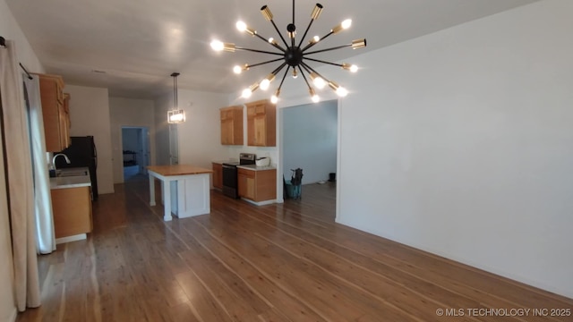 21316 County Road 502, Colcord, OK 74338 - kitchen featuring an inviting chandelier, a sink, stainless steel electric stove, hardwood / wood-style flooring, and a kitchen island