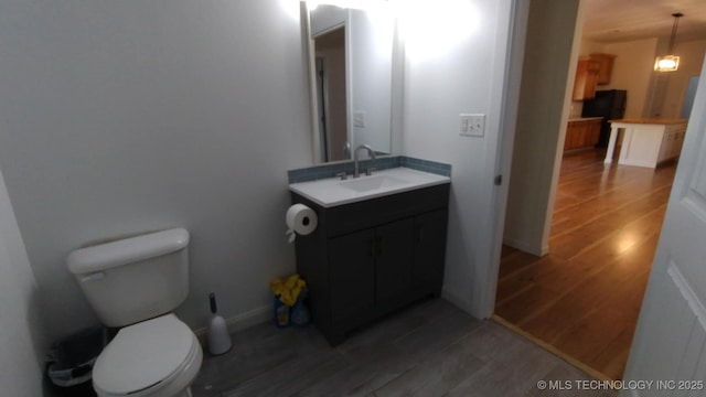 21316 County Road 502, Colcord, OK 74338 - bathroom with toilet, baseboards, vanity, and wood finished floors