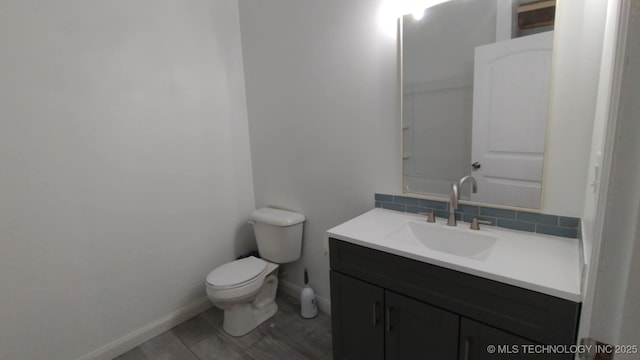 21316 County Road 502, Colcord, OK 74338 - bathroom featuring vanity, toilet, tasteful backsplash, and baseboards