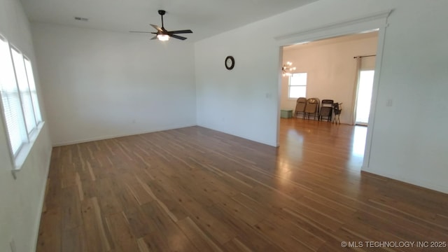21316 County Road 502, Colcord, OK 74338 - spare room featuring visible vents, wood finished floors, and ceiling fan with notable chandelier