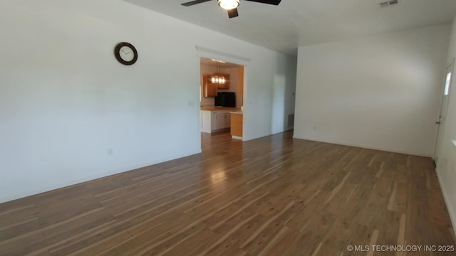 21316 County Road 502, Colcord, OK 74338 - spare room with dark wood-style flooring, ceiling fan with notable chandelier, and visible vents