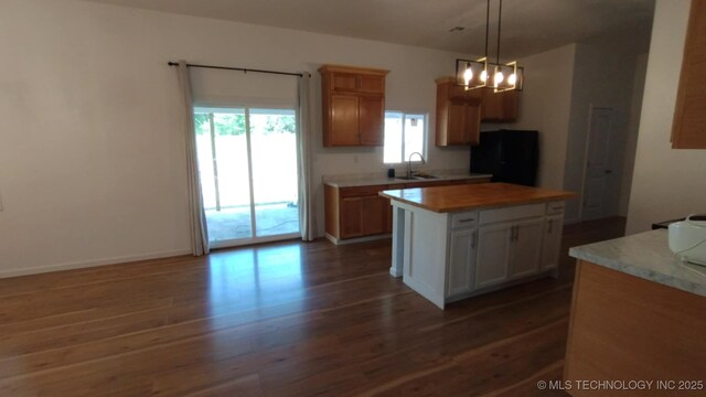 21316 County Road 502, Colcord, OK 74338 - kitchen with a sink, freestanding refrigerator, dark wood finished floors, light countertops, and a kitchen island