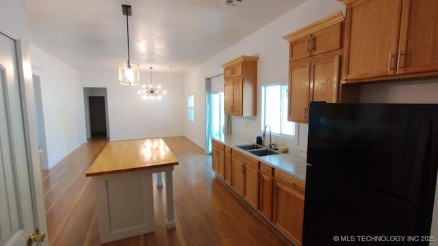 21316 County Road 502, Colcord, OK 74338 - kitchen featuring a sink, freestanding refrigerator, a notable chandelier, and wood finished floors