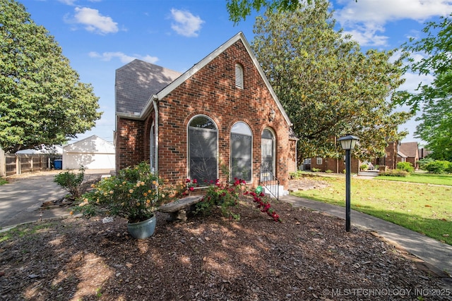 1731 S Florence Pl, Tulsa, OK 74104 - tudor home featuring a front yard, roof with shingles, and brick siding